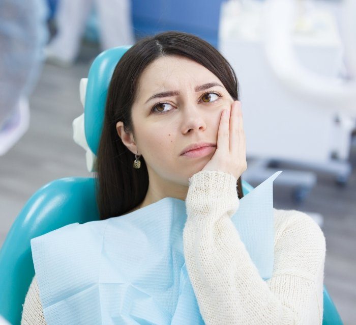 Woman in pain before treatment from her emergency dentist